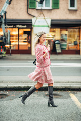  Retro style portrait of beautiful woman with blond hair, walking down the street, wearing red and white plaid blazer