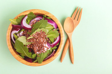 Healthy salad with fresh spinach, red onion and flax seeds