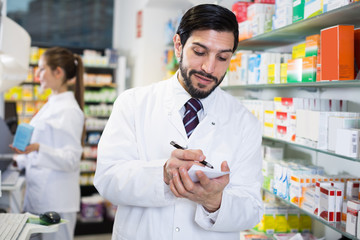 Man pharmacist is inventorying medicines