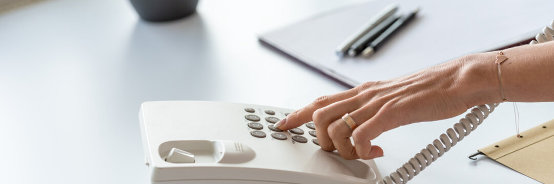 Wide View Image Of Hand Of A Secretary Dialing A Telephone Number