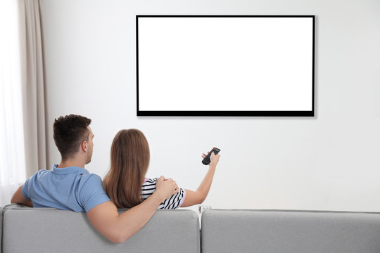 Couple Watching TV On Sofa At Home. Mockup For Design