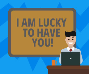 Text sign showing I Am Lucky To Have You. Conceptual photo Expressing roanalysistic feelings and positive emotions Blank Bordered Board behind Man Sitting Smiling with Laptop Mug on Desk