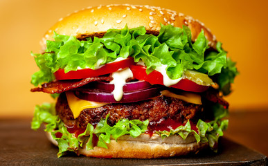 delicious homemade burger for slicing beef on a wooden table, yellow background