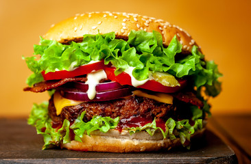 delicious homemade burger for slicing beef on a wooden table, yellow background
