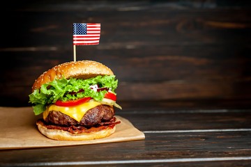 delicious tasty homemade burger with american flag for slicing beef on wooden table