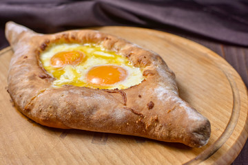 Ajarian traditional flatbread - khachapuri or hachapuri with egg and cheese. Copy text area for menu design or recipe book text.
