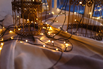 Close - up of garland with yellow lights. Cozy winter or autumn morning at home, warm blanket,