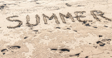 summer written in the sand of the beach