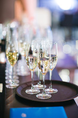 Glasses with different types of aclohol stand on the black dinner table in the restaurant
