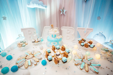 Delicious wedding reception candy bar dessert table full with cakes, sweets, macaroons, eclairs and other types of bakery