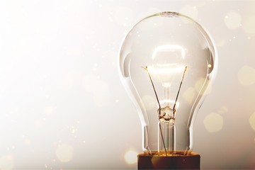 Glowing glass light bulb on background