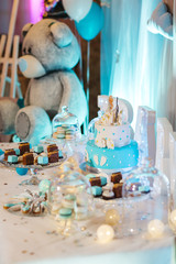 Delicious wedding reception candy bar dessert table full with cakes, sweets, macaroons, eclairs and other types of bakery