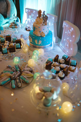 Delicious wedding reception candy bar dessert table full with cakes, sweets, macaroons, eclairs and other types of bakery