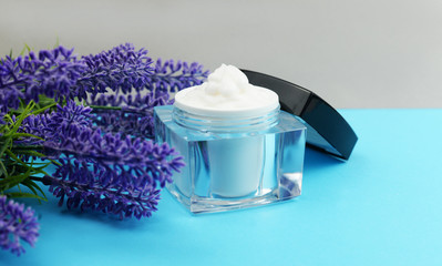 Obraz na płótnie Canvas cream in a glass jar pack for face and hand care with a lavender