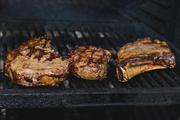 pieces of meat on the bone are grilled