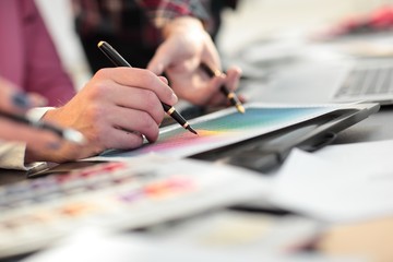 close up.a group of designers discussing the color design of a new project
