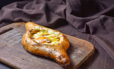 Ajarian traditional flatbread - khachapuri or hachapuri with egg and cheese. Copy text area for menu design or recipe book text.