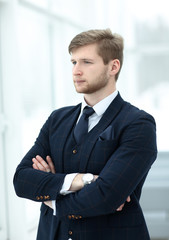 pensive young businessman standing near the office window