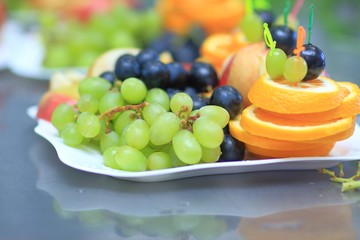close up.plate with grapes and oranges on blurred background