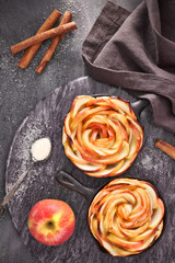 Homemade puff pastry with rose shaped apple slices baked in iron skillets