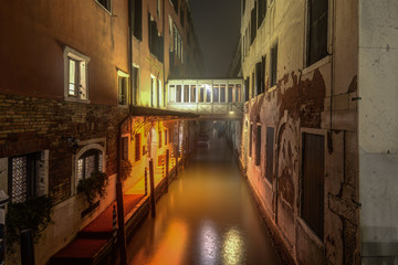 Fototapeta na wymiar Historical buildings at narrow canal at night in Venice,Italy.