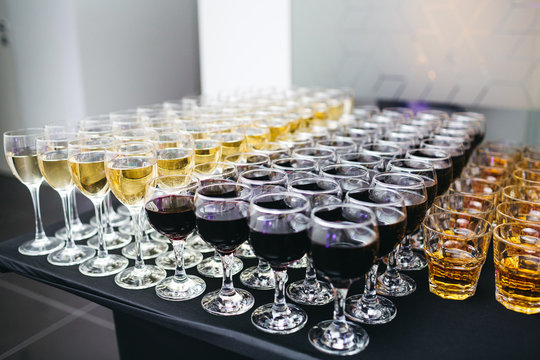 Glasses With Different Types Of Aclohol Stand On The Black Dinner Table In The Restaurant