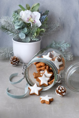 Christmas background with tasty star ginger cookies in a glass jar with winter floral decorations