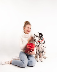 A young woman sitting with red box gift and dalmatian dog. Festive mood. Smiling girl. Woman and...