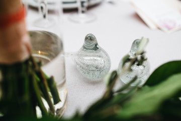 Dinner table serving. Violet and beige tones, pastel colors. Beautiful decoration of wedding banquet in restaurant with glasses, plates, forks and knives, white tablecloth.