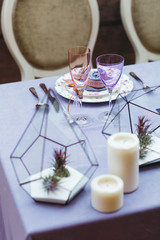 Wedding presidium in restaurant, free space. Wedding banquet table for newlyweds with flowers, greenery, pink cloth and bulbs. Lush floral arrangement on wedding table. Luxury wedding decorations