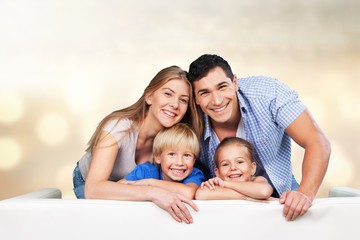 Fototapeta na wymiar Beautiful smiling family sitting at sofa at home