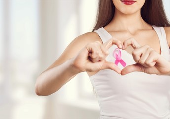 Woman chest with pink badge to support breast cancer cause,