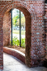 Brick sidewalk corridor path entrance, arch, archway to Martello Botanical Garden Center with nobody, architecture in Florida Key West, keys city