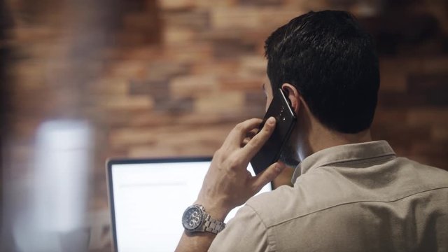Young business man working in modern office cafeteria. Latin businessman with pc at corporate workplace. Busy hispanic manager with laptop computer at work. Concept of job and professional occupation
