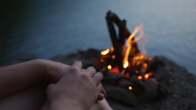 Hands of a person standing by a fire