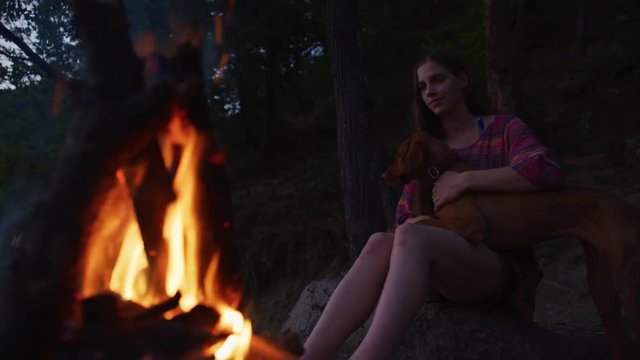 Woman And Dog At A Campfire