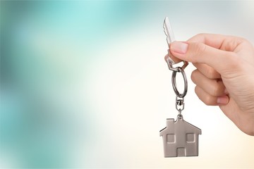 House key in hand on blurred background