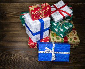 background. Gifts in festive color packaging, lie on a wooden floor. New Year, Christmas, Saint Nicholas, Santa.