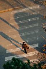 man crossing the street during sunset