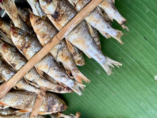 Fish skewers placed on banana leaves