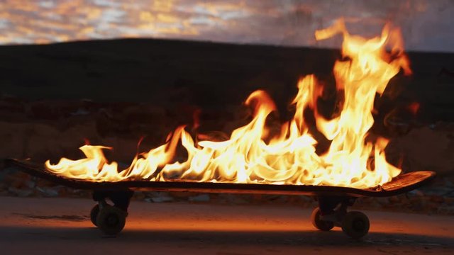 Burning skateboard at sunset