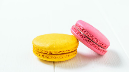 Red and white macaroon cake on a white wooden table.