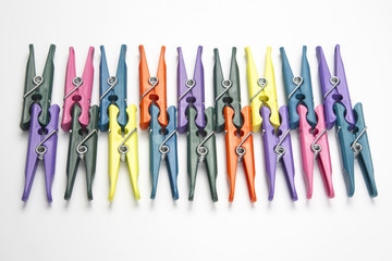 Colored plastic clothespins for clothes on a white background