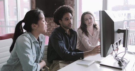 Coworkers looking at a desktop computer together