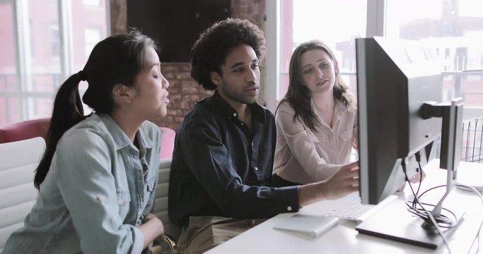 Coworkers looking at a desktop computer together
