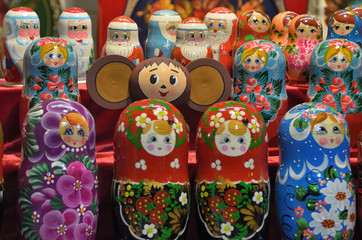 Cheburashka on the background of nesting dolls and figures of Santa Claus in the background