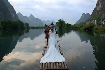 Making wedding photos  on river near  karst mountains and limestone peaks of Yulong River, Yangshuo, Guilin, China,