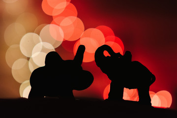 silhouette of 2 elephant toys, colorful bokeh