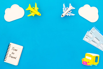 Time to travel. Accessories for treveling with children, tickets, notebook and toys on blue background top view mock-up