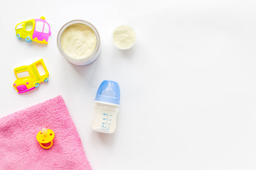 Baby care with craft toys for newborn. Rattle and powdered milk. White background top view copy space